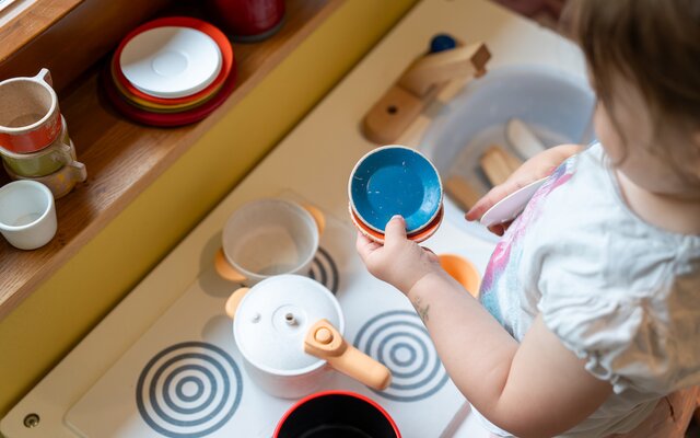 Kind beim Spielen in der Kinderküche